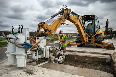 Minnich Manufacturing machine-mounted drill attached to a backhoe