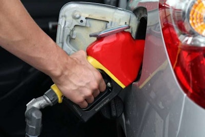 hand pumping gas into vehicle