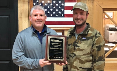 Ed Harseim and Ron Parks holding Hyundai First Choice Farm & Lawn plaque