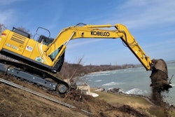 Kobelco SK170LC dumping a bucket of dirt near water
