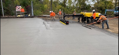 construction workers paving with equipment