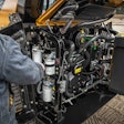 man performing maintenance work on heavy duty equipment