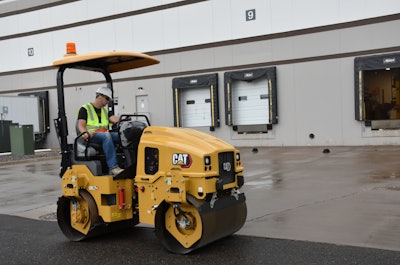 Man operating Caterpillar utility compactor