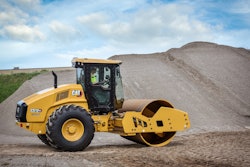 Man operating caterpillar single drum vibratory compactor