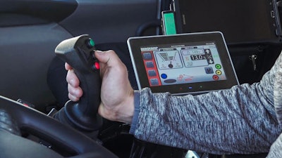 man operating joystick with touchscreen system to the side