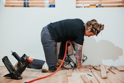 woman laying down wood on floor