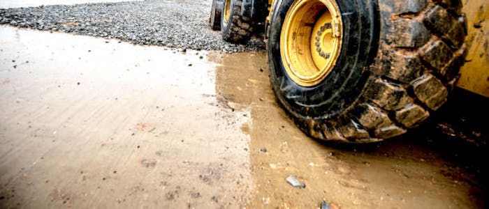heavy equipment wheel on wet pavement