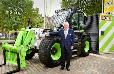 Lord Bamford stands next to JCB hydrogen-powered construction equipment
