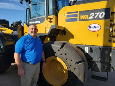 Mike Kunin vice president of national accounts standing next to a Komatsu WA270