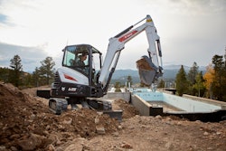 Bobcat E35 compact excavator scooping up dirt on a jobsite