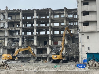Cat 340 UHD excavators tearing down a tall building.