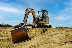 Cat mini excavator with grade control cutting a slope