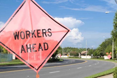 workers ahead sign on side of street