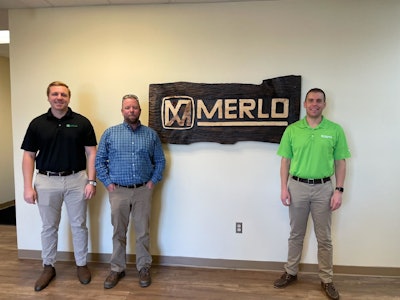Brooks Tractor representatives stand in front of Merlo sign.