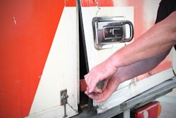 Thief breaking into a truck with a crowbar.