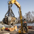 Caterpillar MH3026 material handler lifting debris.
