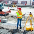 Construction worker using Trimble base station on a jobsite.