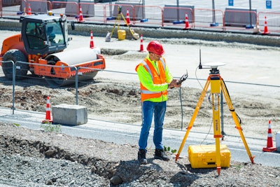 Construction worker using Trimble base station on a jobsite.