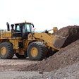 Cat 988K XE Wheel Loader digging into a pile of dirt.