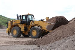 Cat 988K XE Wheel Loader digging into a pile of dirt.