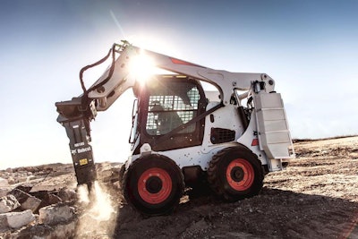 Operator running breaker attachment on a Bobcat skid steer.