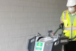 Construction worker using a floor sander.