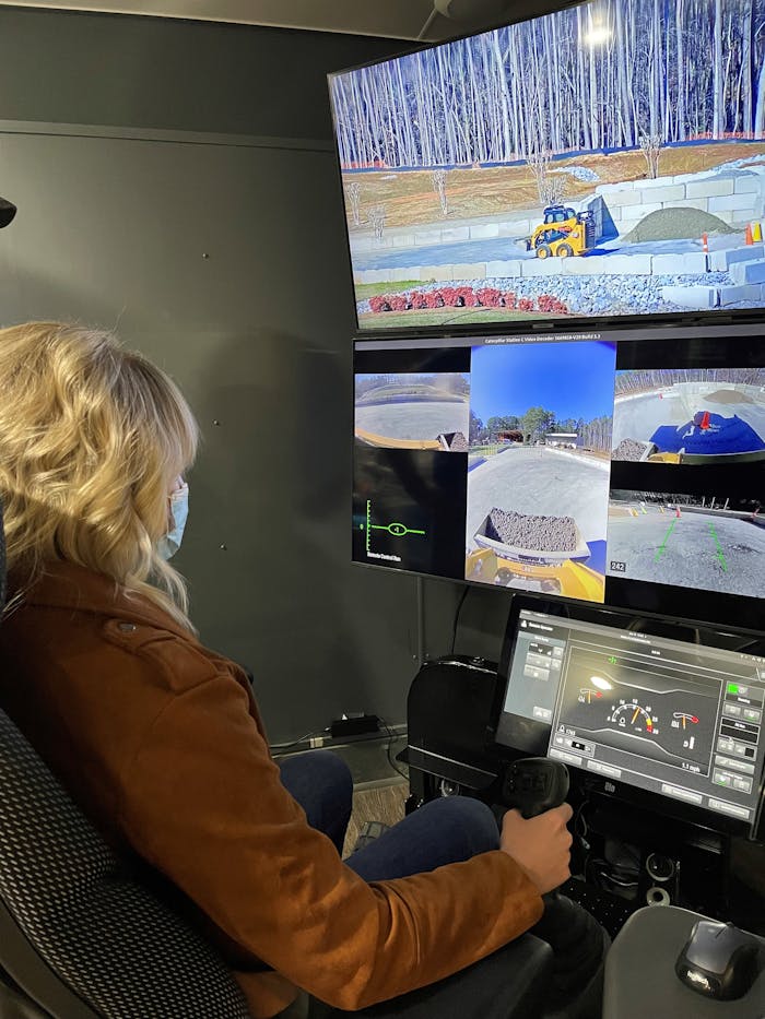 Equipment World's Jordanne Waldschmidt remotely operates a skid steer in North Carolina from the Las Vegas Convention Center.