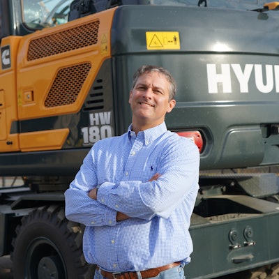 Jesse Beasley, chief operating officer, National Equipment Dealers next to Hyundai HW180.