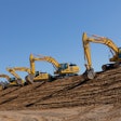 Four Komatsu excavators digging on a jobsite.