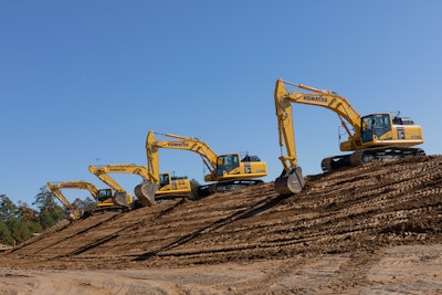 Four Komatsu excavators digging on a jobsite.