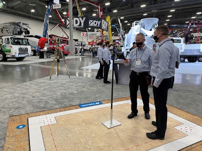 Topcon employees use MC-Mobile to check elevation on a simulated jobsite at World of Concrete.