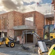 Man looking at tablet on a connected jobsite with Volvo construction equipment.