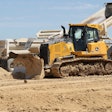 John Deere bulldozer pushes dirt on a jobsite.