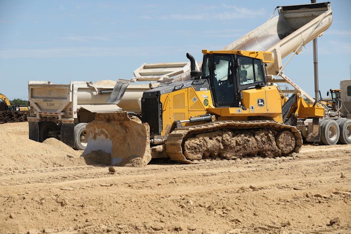 John Deere bulldozer pushes dirt on a jobsite.