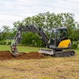 Mecalac compact excavator digging in the dirt.