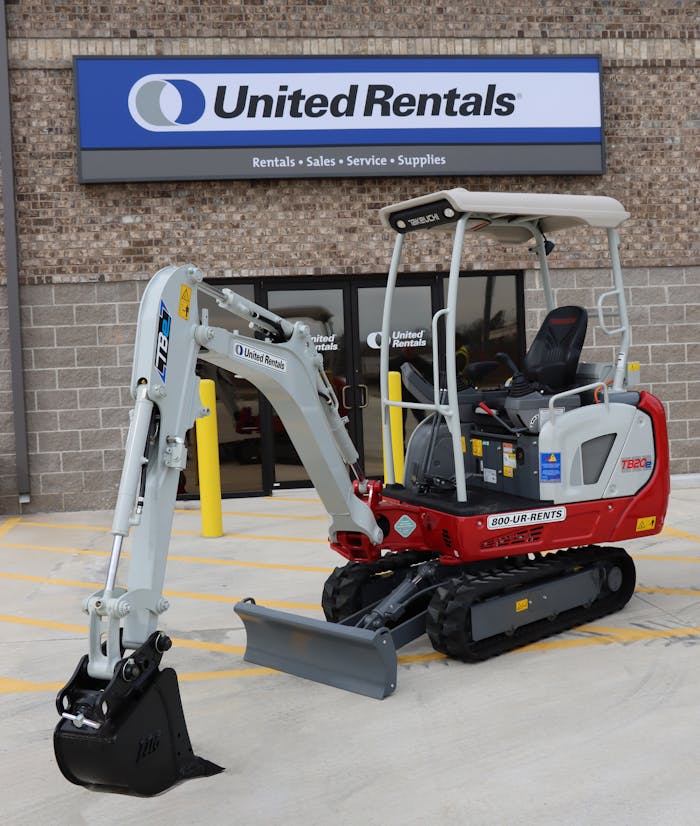 Takeuchi TB20e electric compact excavator parked in front of a United Rentals store.