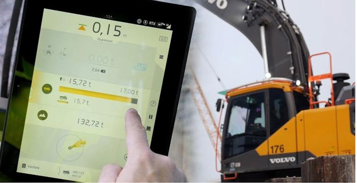 Man checks a Volvo excavator's loading efficiency on a tablet.