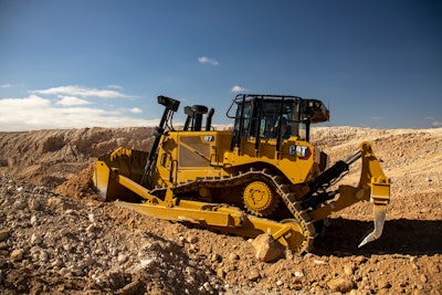 Caterpillar D7 dozer with ripper pushing dirt.