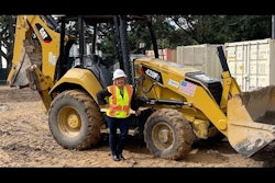 woman contractor standing next to cat 420f2 equipment