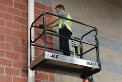 Worker using JLG 1030P low-level access lift to work on a pipe