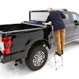 Man uses optional ladder to see into his Decked tool box in the back of a truck.