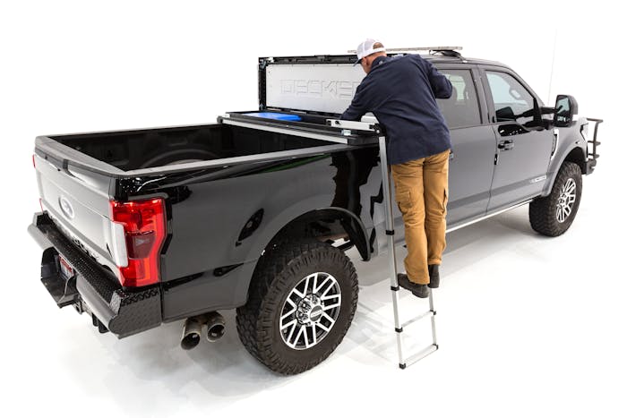Man uses optional ladder to see into his Decked tool box in the back of a truck.