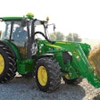 John Deere 5M Series tractor hauling a hay bale