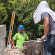 Construction workers working in extreme heat with a wet towel on their heads