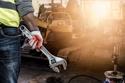 Equipment technician fixing a mini excavator