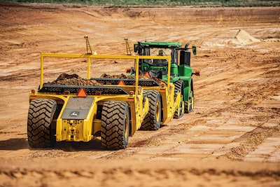 John Deere tractor pulling towed scraper.