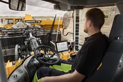 Volvo wheel loader operator in cab using app tablet
