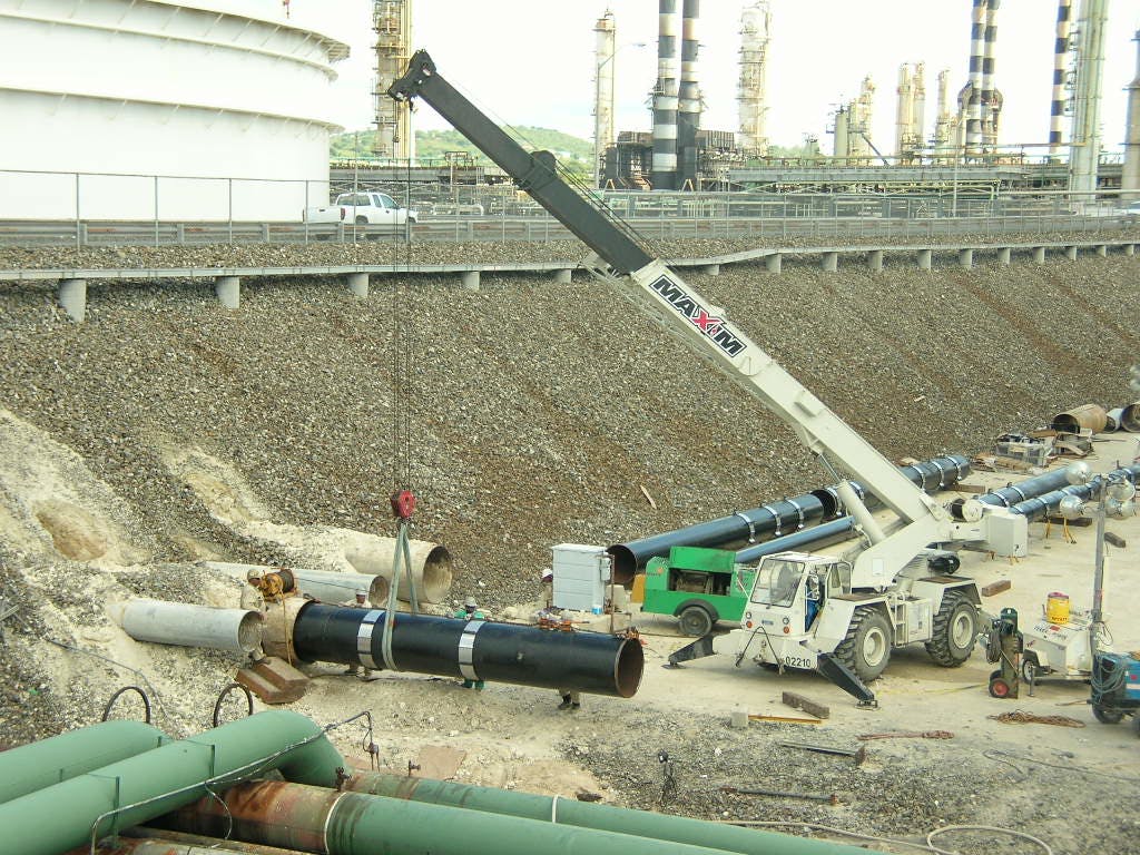 Crane lifting a pipe on a construction site