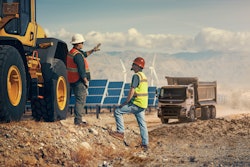 Construction workers on a jobsite with solar panels and windmills.
