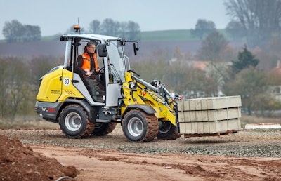 Wacker Neuson WL28 articulated wheel loader carrying concrete blocks